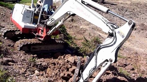 mini excavator trenching on hillside|mini drain pipe steep hill.